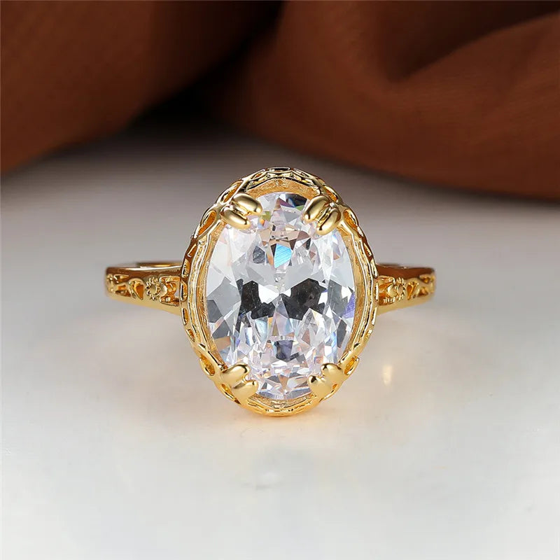 oval shaped clear crystal gemstone inside a thick gold plated ring 
