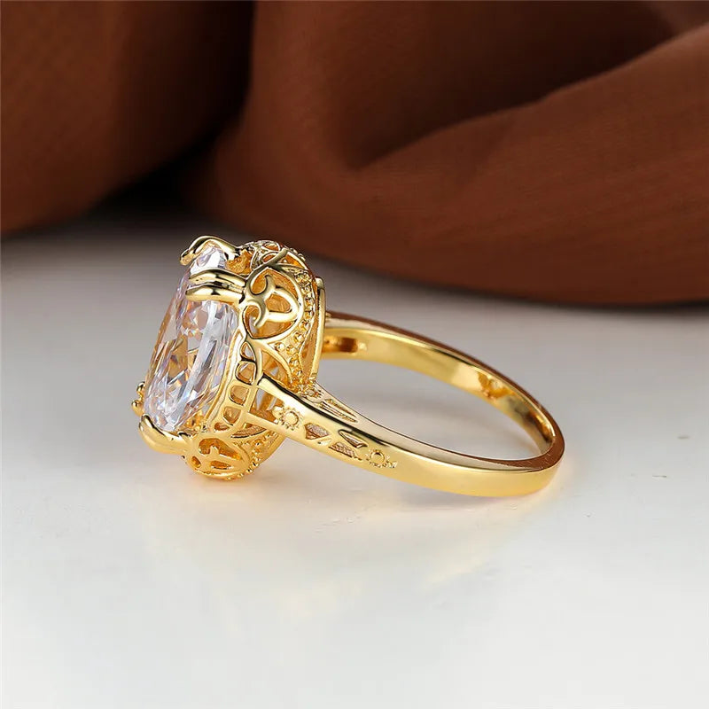 oval shaped clear crystal gemstone inside a thick gold plated ring