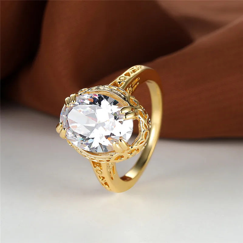 oval shaped clear crystal gemstone inside a thick gold plated ring