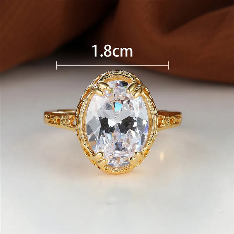 oval shaped clear crystal gemstone inside a thick gold plated ring