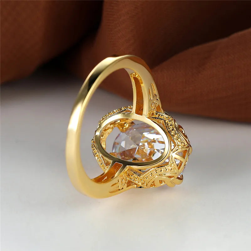 oval shaped clear crystal gemstone inside a thick gold plated ring